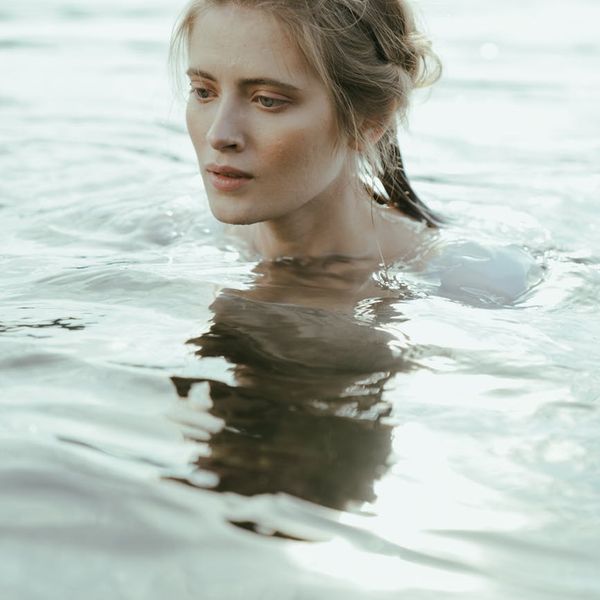 Person meditating peacefully in a calm, minimalist environment.